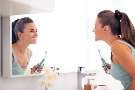 woman brushing teeth to prevent gum inflammation